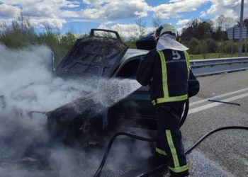 Los Bomberos sofocan el incendio de un turismo en la AS-17, después de la salida de Tiñana (Siero)